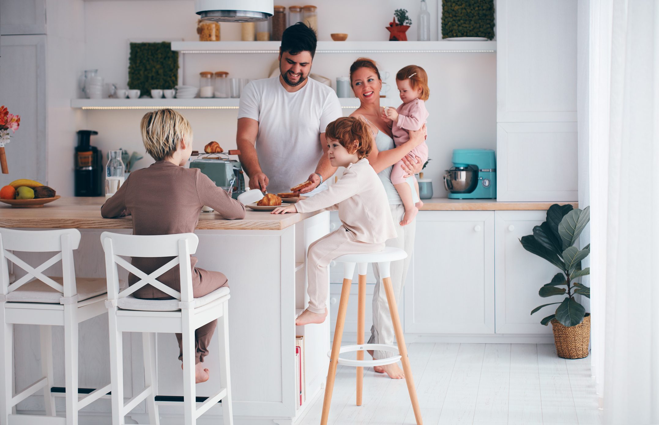 happy family with three kids having breakfast in the kitchen in the morning