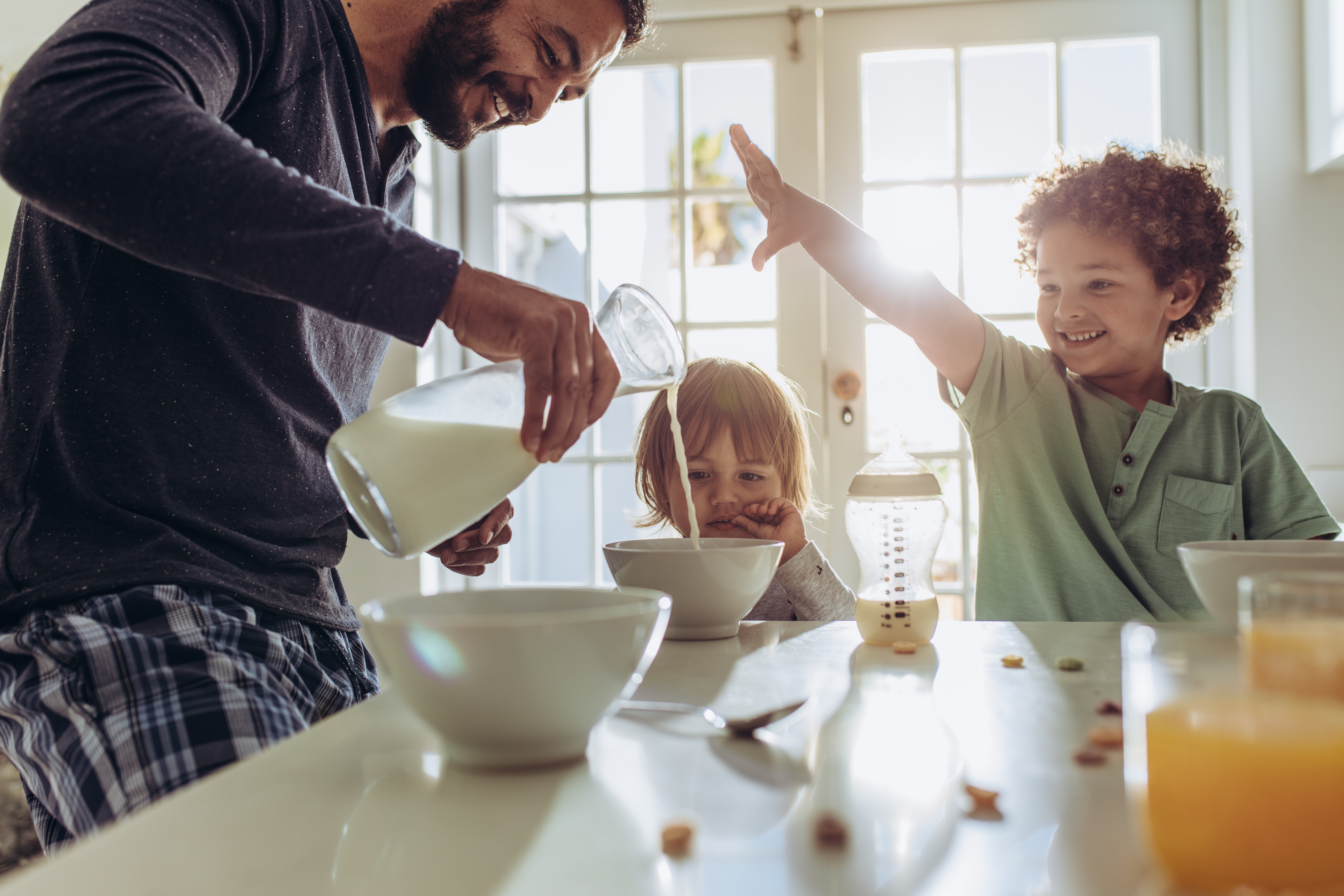 Man having fun preparing breakfast at home with his kids.
